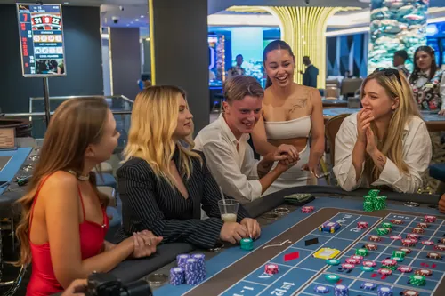 Players laughing around the roulette table